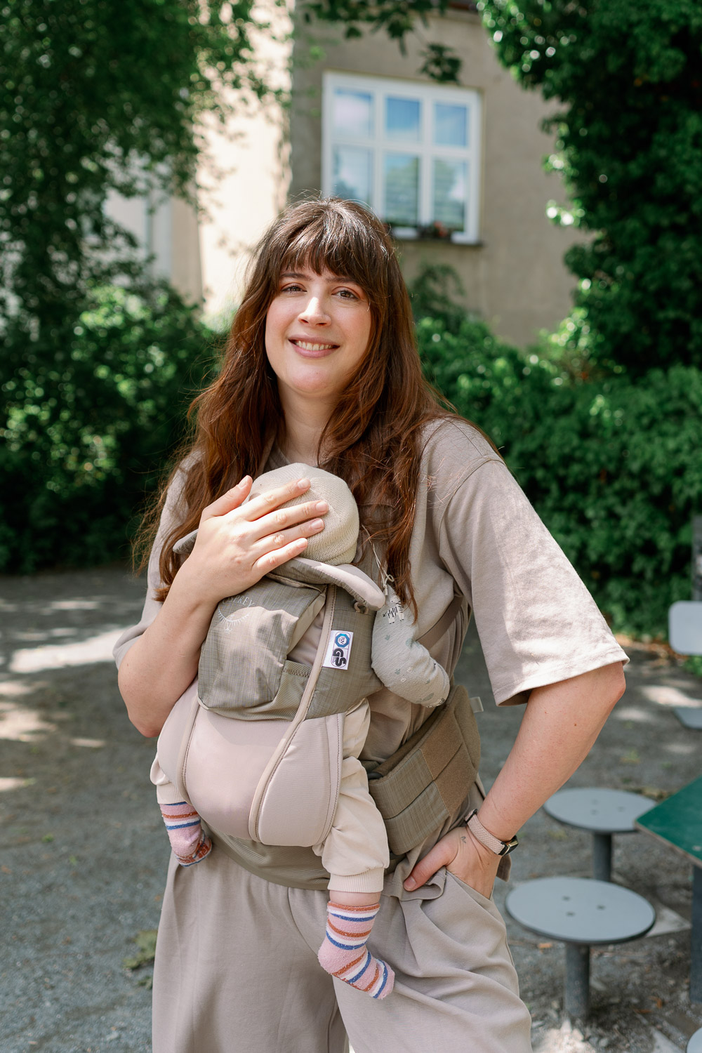 Andrea mit Baby in der Trage bei einem Spaziergang – Symbolbild für entspanntes Reisen mit Baby
