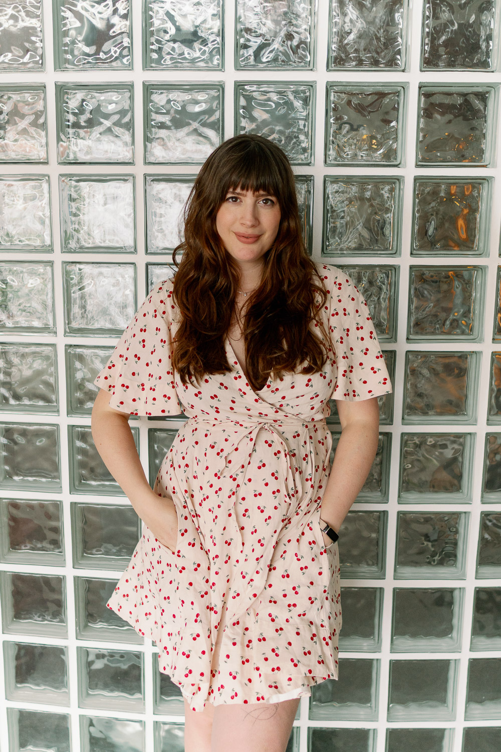 Andrea von andysparkles im Sommerkleid mit Kirschenprint und natürlich schönen Haaren vor Glaswand