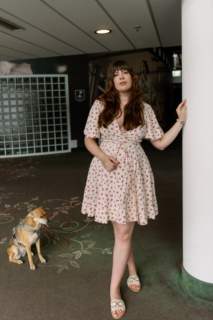 Andrea von andysparkles mit natürlich schönen Haaren und Sommerkleid neben Hund und Säule