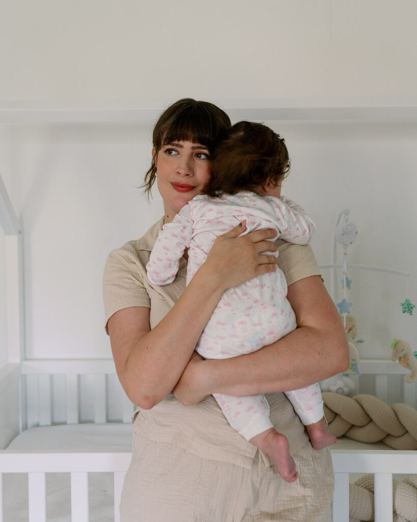 Babynamen für Mädchen finden – Andrea von andysparkles hält ihre Tochter im Kinderzimmer im Arm
