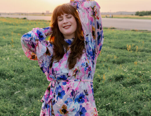 Andrea von andysparkles im bunten Kleid mit langen Ärmeln beim Sonnenuntergang auf dem Tempelhofer Feld in Berlin.