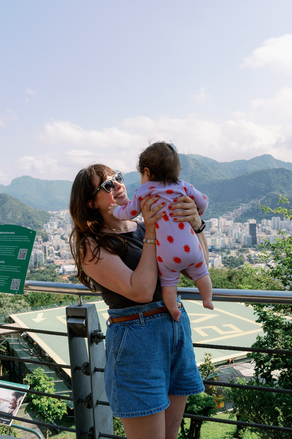 Andrea von andysparkles hält ihr Baby mit Blick auf Rio de Janeiro, Brasilien - Fernreise mit Baby