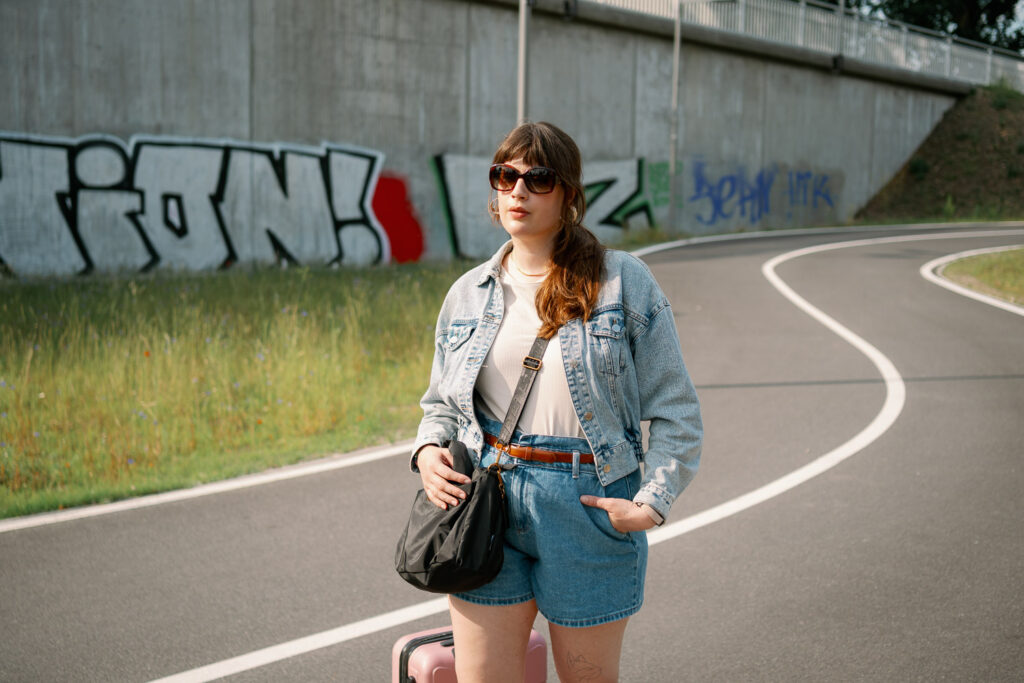 Andrea von andysparkles im Jeansshorts- und Jacken-Look mit Handgepäck – Packideen, wie viele Kleidungsstücke für 7 Tage Urlaub reichen