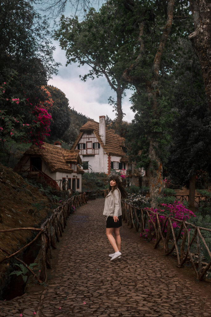 Andrea von andysparkles spaziert durch das malerische Dorf Santana mit traditionellen Strohdachhäusern – Solo Travel Madeira