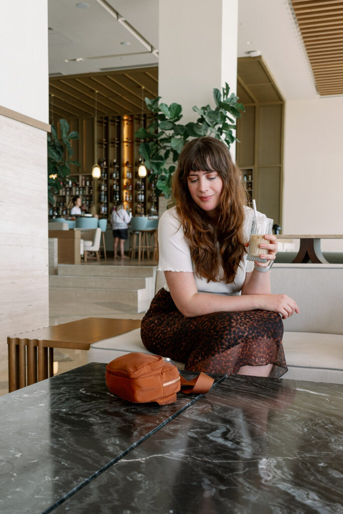 Andrea von andysparkles entspannt mit Eiskaffee und Tasche im Hotel