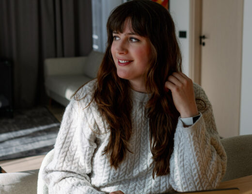 Andrea Funk sitzt im gemütlichen Wohnzimmer am Laptop und denkt über ihre Longevity-Basics zum gesund alt werden nach