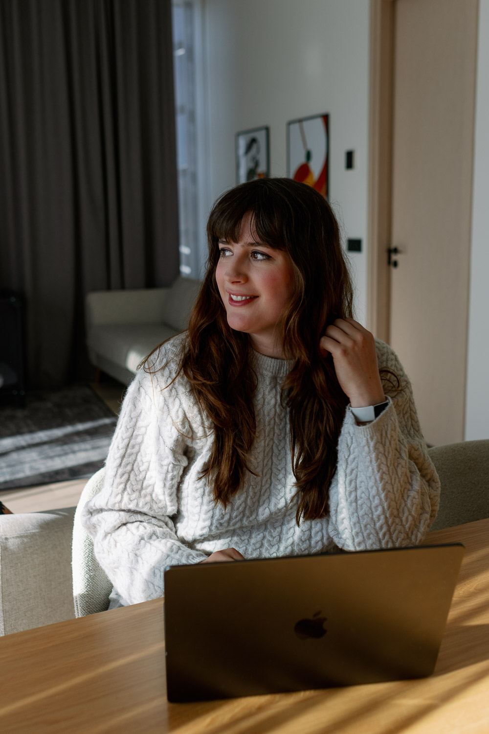 Andrea Funk sitzt im gemütlichen Wohnzimmer am Laptop und denkt über ihre Longevity-Basics zum gesund alt werden nach