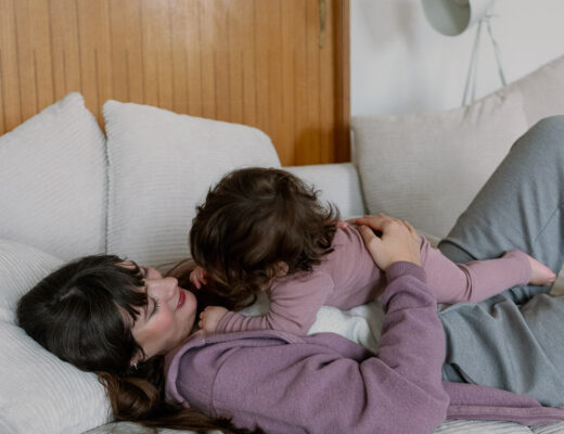 Entspannung im Alltag mit Kindern: Andrea von andysparkles liegt mit Baby auf dem Sofa und kuschelt im Wohnzimmer