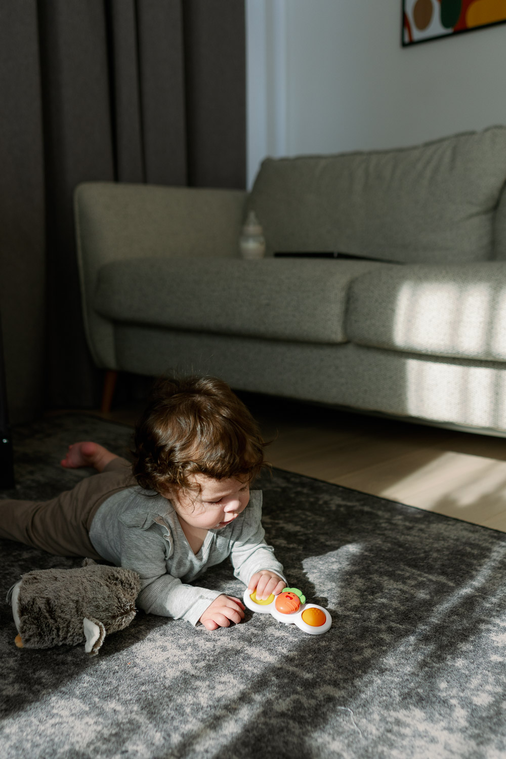 Geschenkideen für Kinder im Alltag: Baby spielt auf dem Teppich mit seinem Lieblingsspielzeug