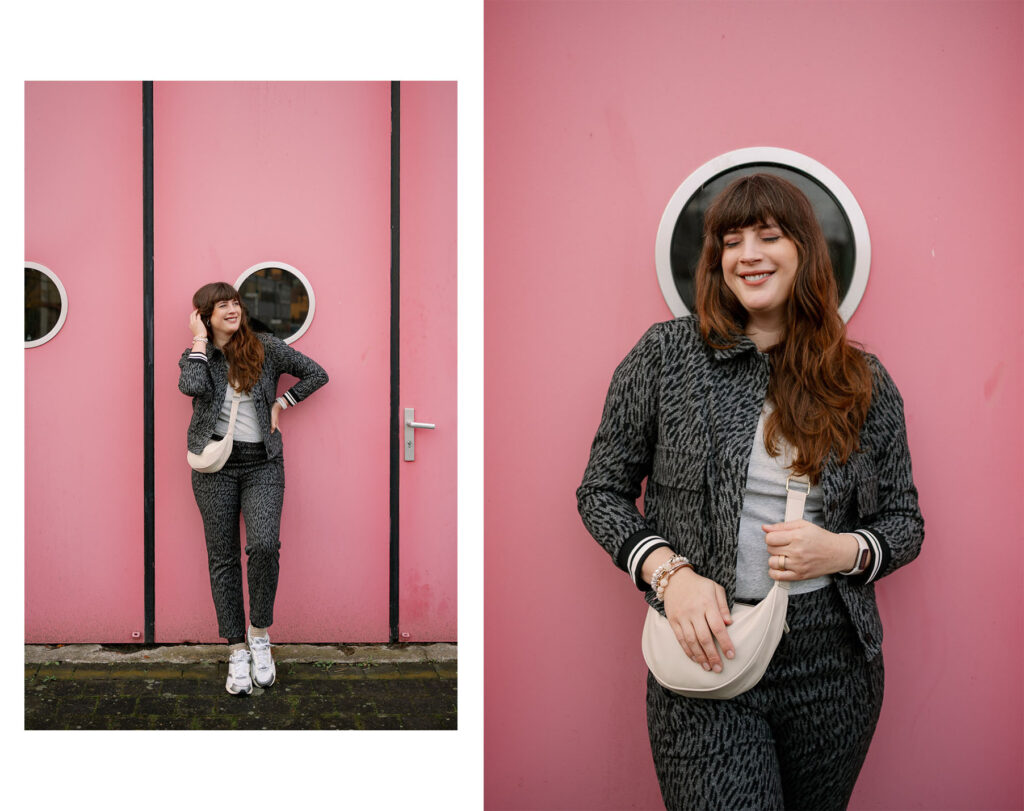 BH nach dem Abstillen Outfit: Andrea von andysparkles vor pinker Wand im grauen Zweiteiler mit Sneakern und Crossbody Bag