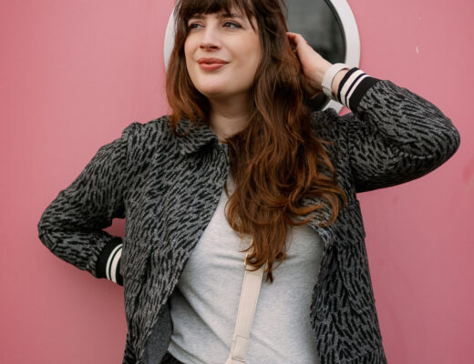 BH nach dem Abstillen Modefoto: Andrea von andysparkles im grauen Zweiteiler vor pinker Wand, Close-up Portrait mit Crossbody Bag