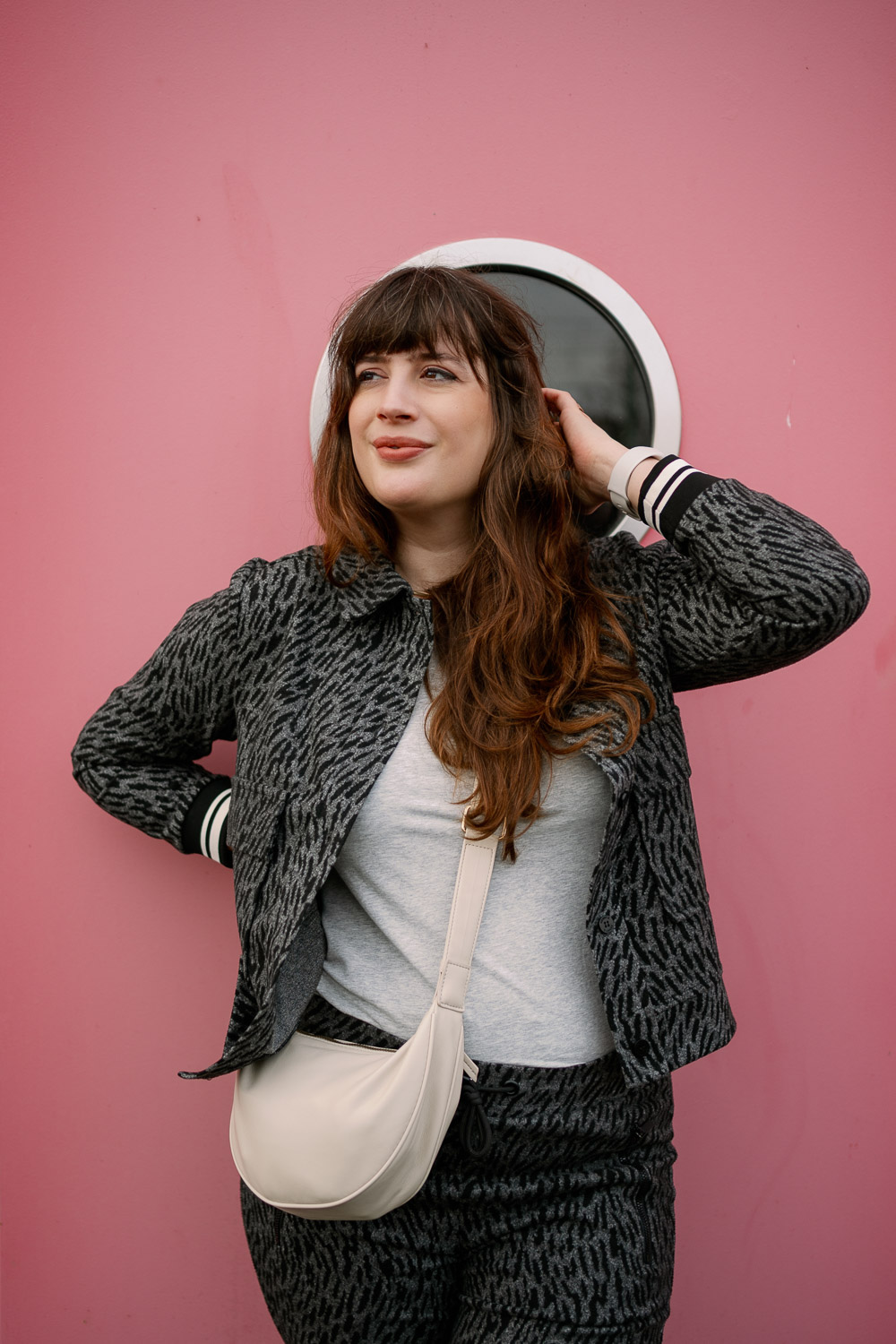 BH nach dem Abstillen Modefoto: Andrea von andysparkles im grauen Zweiteiler vor pinker Wand, Close-up Portrait mit Crossbody Bag