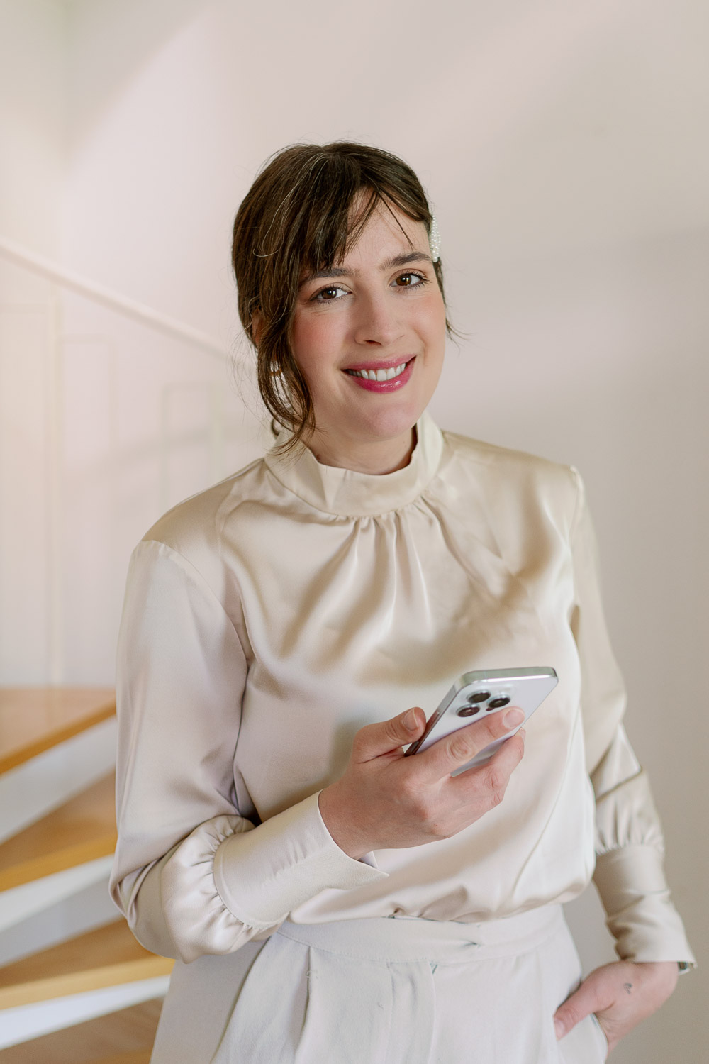 Andrea von andysparkles mit Smartphone in heller Bluse für einen femininen und lässigen Business-Look