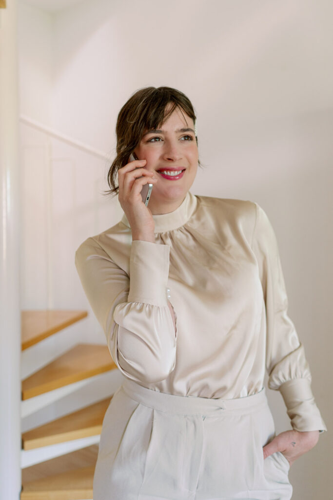 Andrea from andysparkles is on the phone in a light blouse and shows off an elegant, everyday office outfit