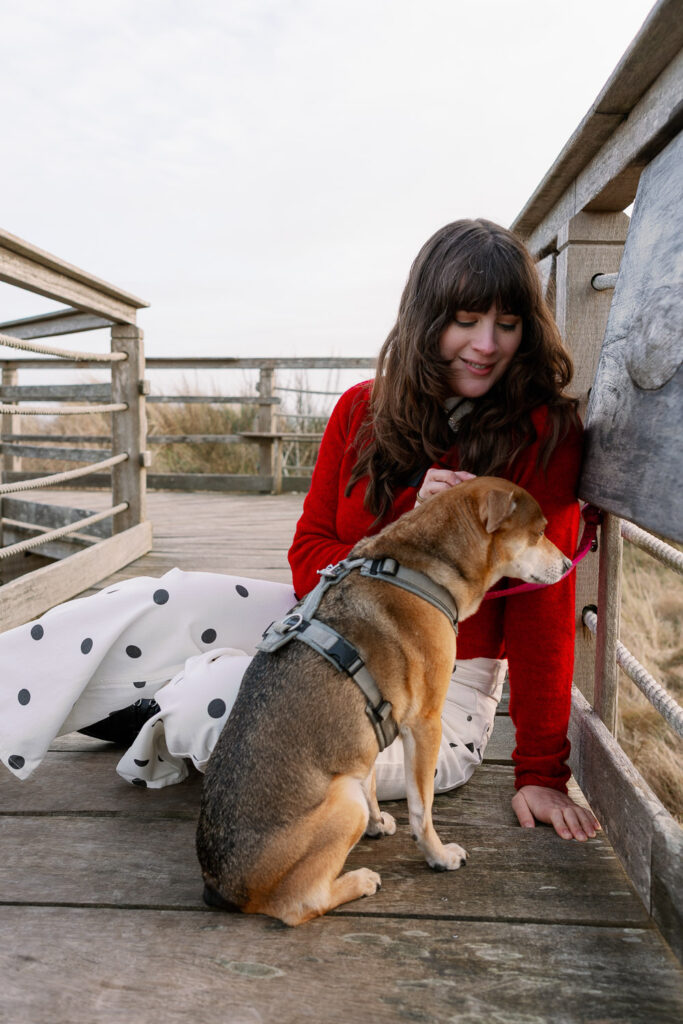 Andrea from andysparkles with her dog on a wooden platform on Juist