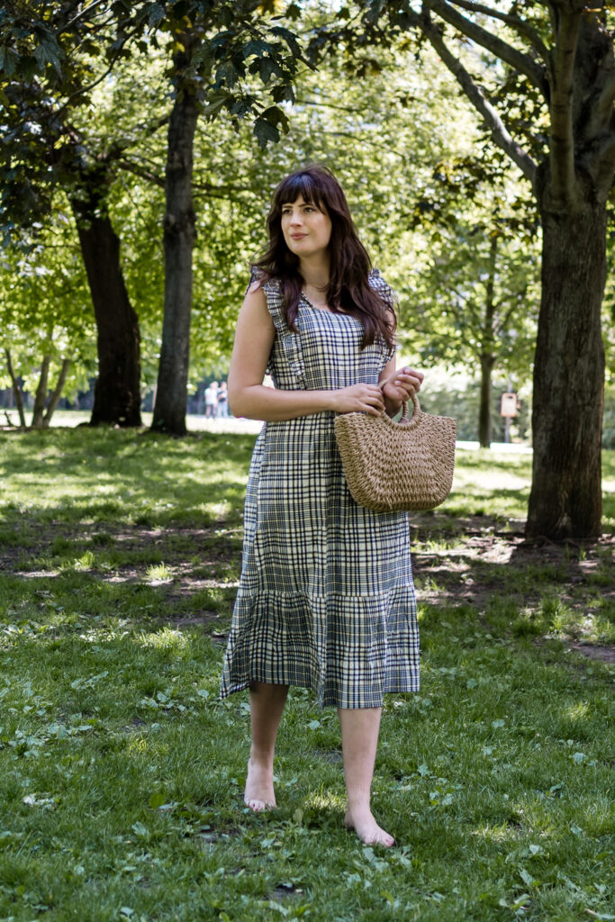 Andrea from andysparkles in a summer dress between trees in Berlin