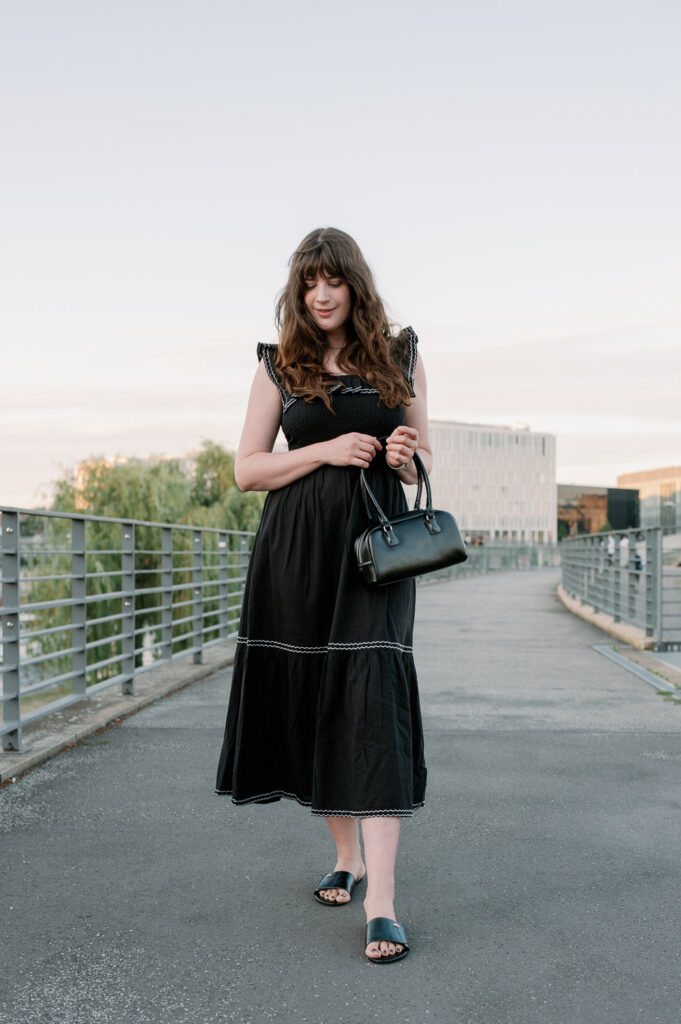 Andrea von andysparkles im schwarzen Midikleid für große Frauen mit kleiner Handtasche