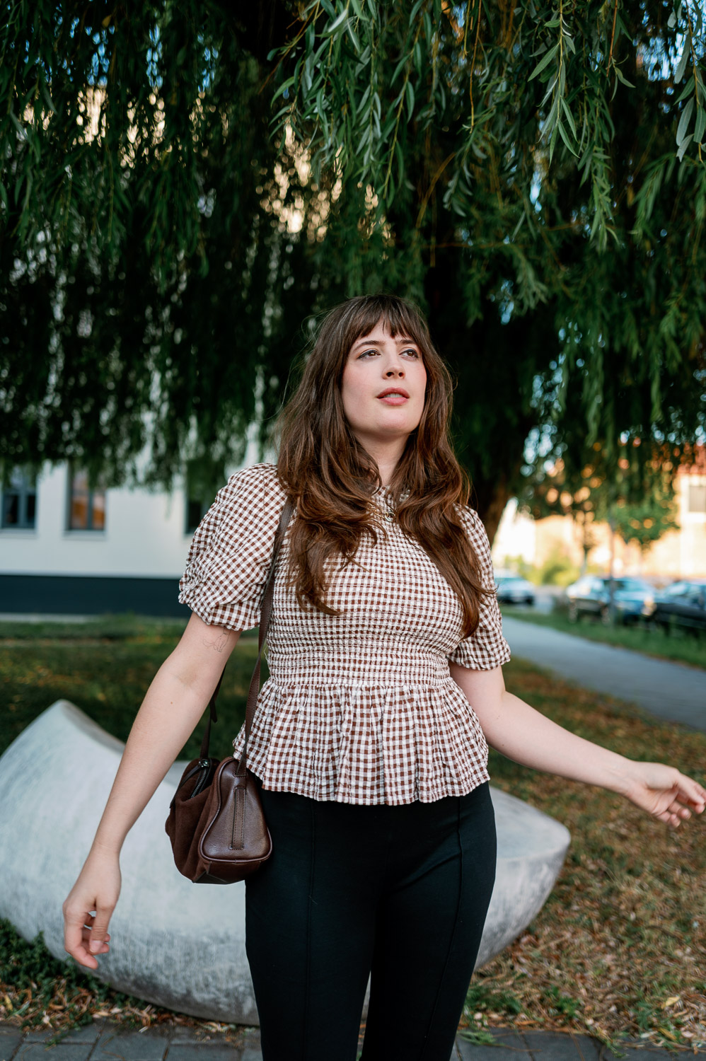 Andrea von andysparkles mit kleiner brauner Schultertasche und kariertem Fashion-Oberteil