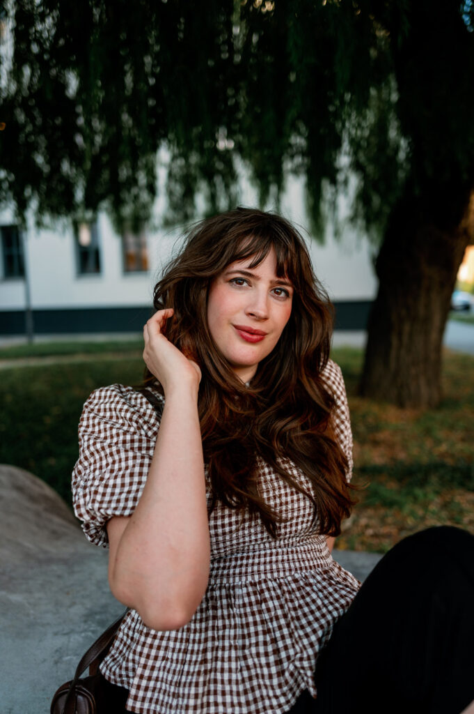 Andrea von andysparkles mit brauner Handtasche und kariertem Oberteil in Berlin
