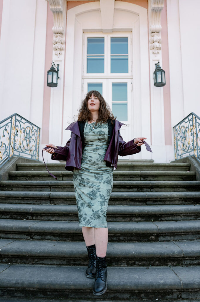 Andrea von andysparkles in schwarzen Schnürboots und Blumenkleid auf einer Schlosstreppe – gute Schuhe bei Fußproblemen