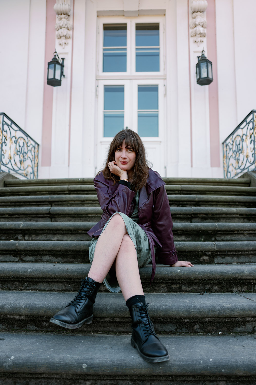 Andrea von andysparkles sitzt mit bequemen schwarzen Boots auf einer Steintreppe